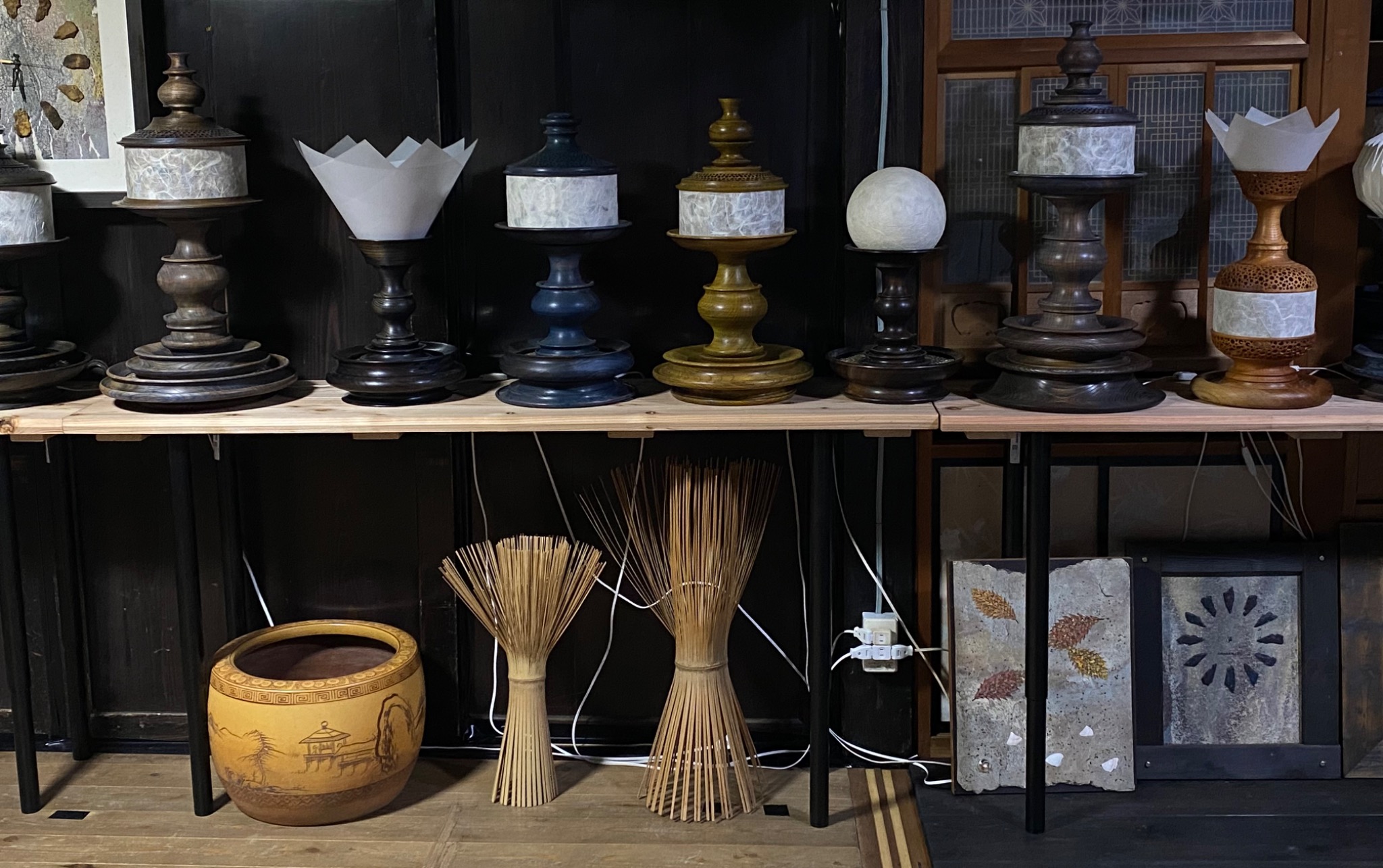 展示室に並ぶ木と和紙の灯りの作品、竹の造形と額装作品